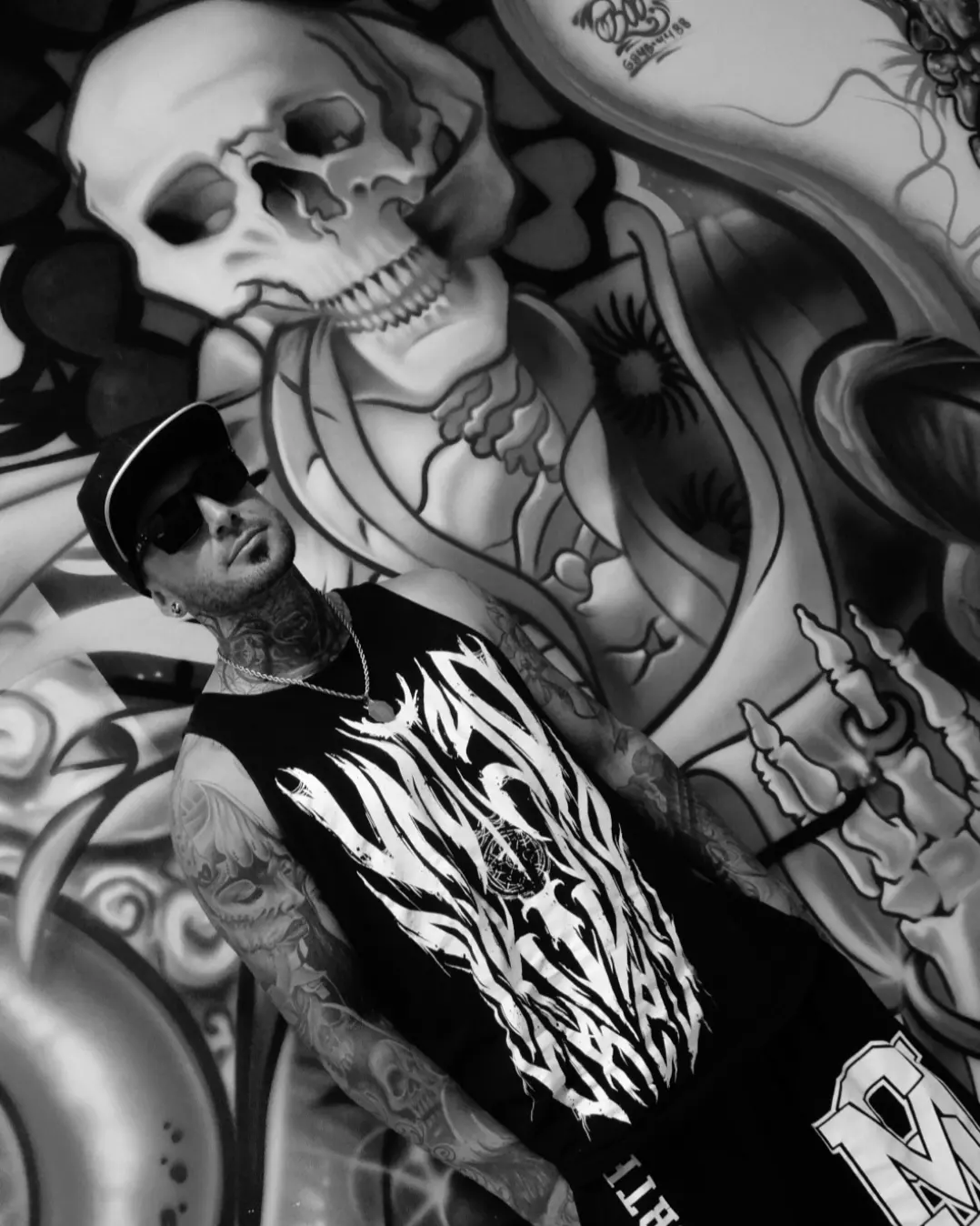 Thiago Oliveira em frente a um mural de caveira
